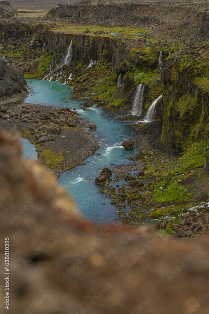 Obraz premium Steep Moss Covered Canyon with Turquoise River and Waterfalls in Iceland