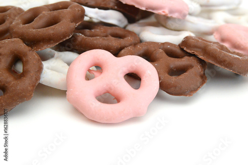 Colorful chocolate covered pretzels on white background