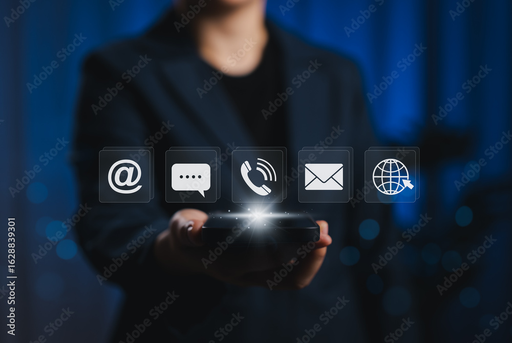 Fototapeta premium Contact Us and Customer Support Service Concept. Businessperson holding smartphone with contact icons, including email, phone, chat, and web symbols, digital customer service, communication channel,