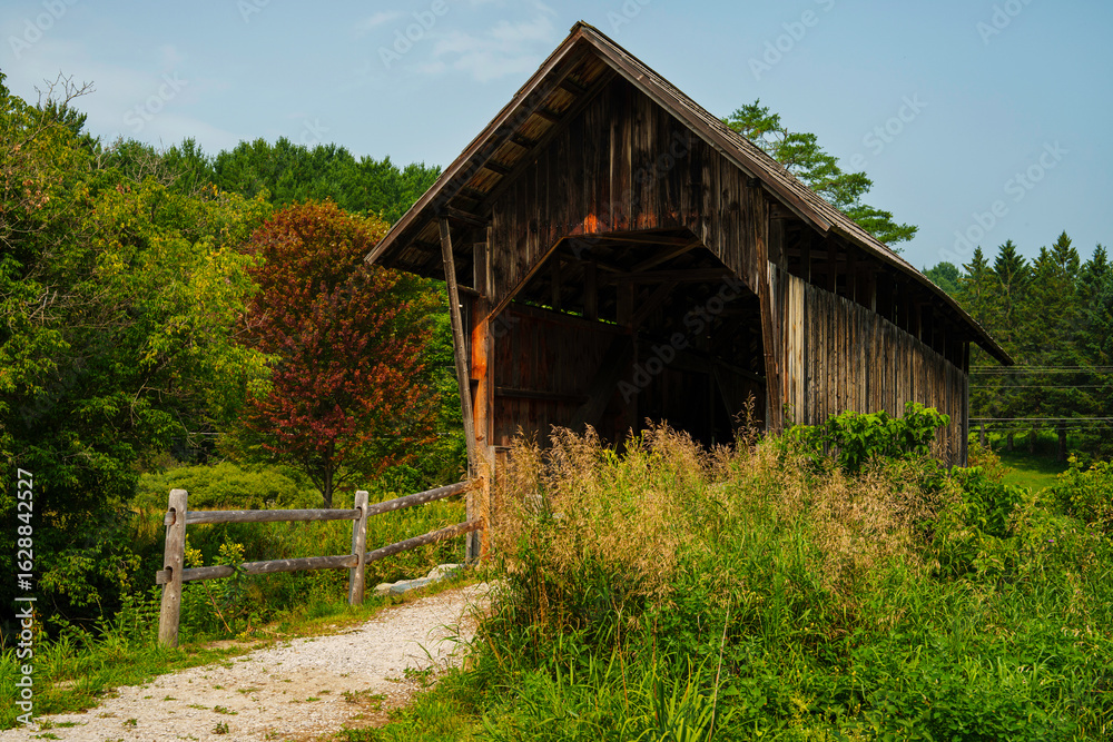Obraz premium The Martin Covered Bridge, a landmark agricultural bridge built in 1890, spans the Winooski River just off U.S. Route 2 in southern Marshfield, Vermont.