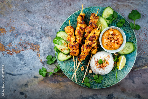 Foto Sate Ayam- Grilled chicken satay sate skewers with peanut dipping spicy sauce, s