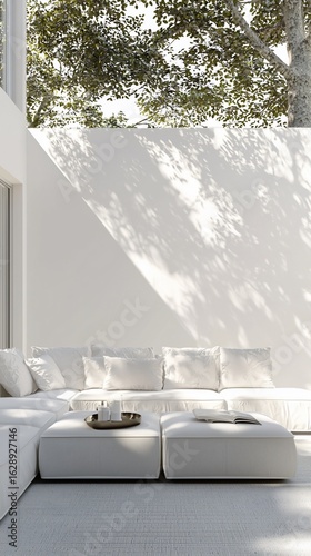 Serene white living room with sun-dappled wall and plush white sectional sofa