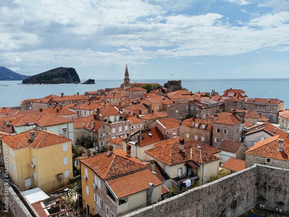 Fototapeta premium Aerial view of Old Town Budva on the Adriatic coast, Montenegro, with marina and red-tiled roofs. g.