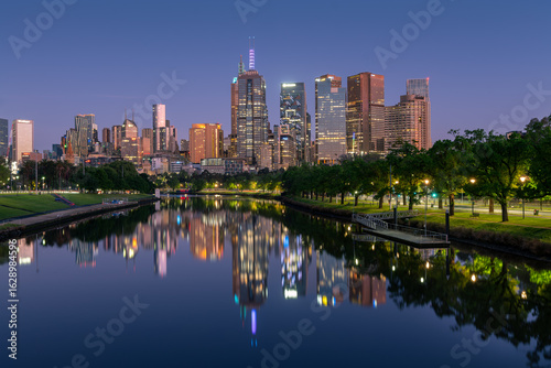 Fotografía The inner city high-rise buildings of Melbourne, Victoria, Australia are reflected in the Yarra River on a  calm spring morning