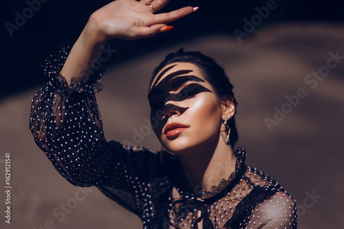 Photography Woman's Face with Shadow Traces from Her Hand, Dramatic Play of Light and Shadow