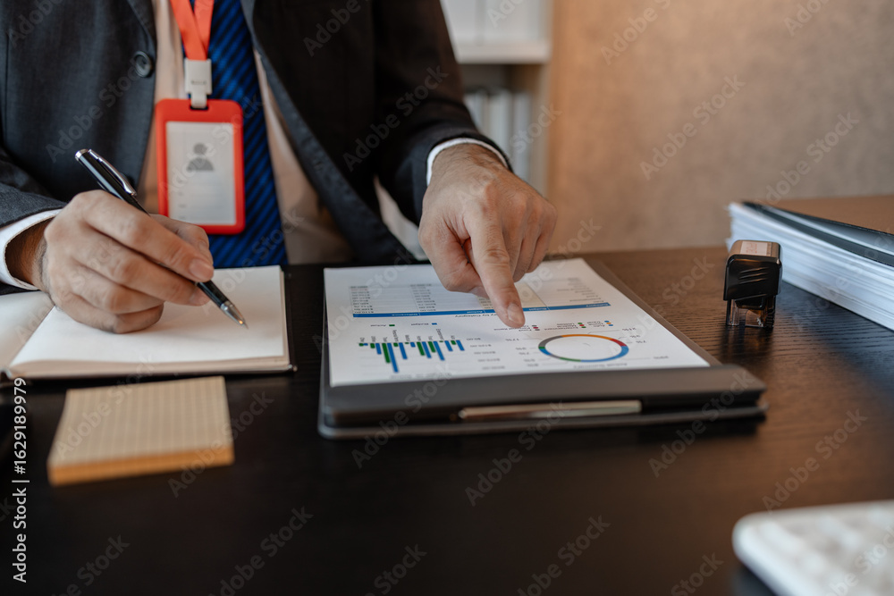 Fototapeta premium an accounting and financial officer is working on documents in the office, a businessman is reviewing his company's historical budget statistics, finance, marketing