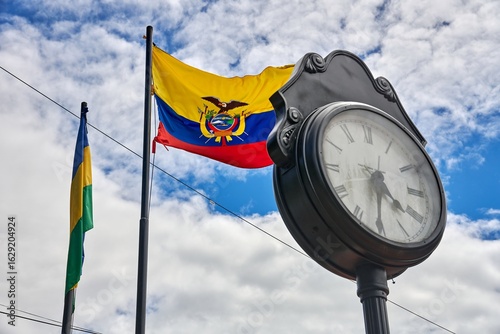 Ecuadorian flag waving beside vintage clock in a vibrant city square, showcasing cultural heritage and historical significance in Latin America