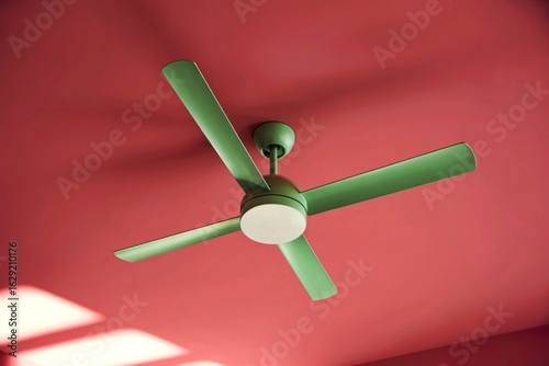 Modern green ceiling fan with integrated light on a pink ceiling