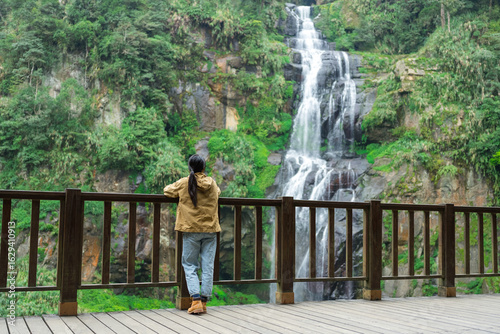 Outdoor woman hiking and enjoying waterfall scenery view