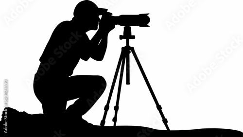 Silhouette of a kneeling photographer using a tripod and camera for taking pictures outdoors scene view