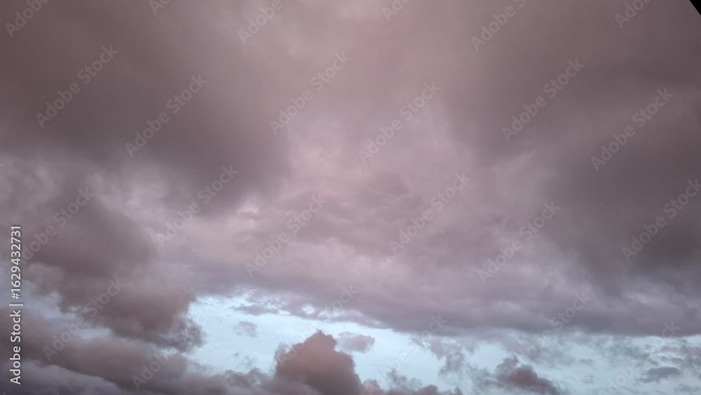 Obraz premium dark rain clouds float against a blue sky, evening