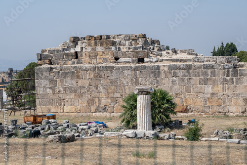 Принти на полотні Visitors discover the remnants of ancient architecture at Pamukkale, featuring a noteworthy column among the ruins and surrounding vegetation