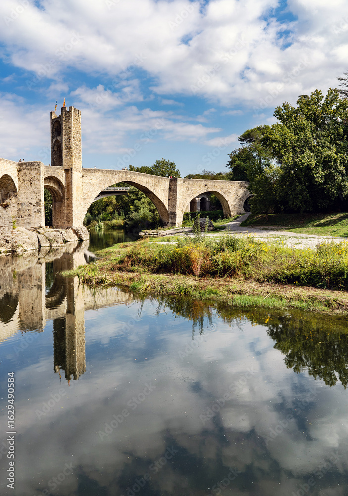 Obraz premium Medieval Stone Bridge Reflecting in River, in Besalu, spain