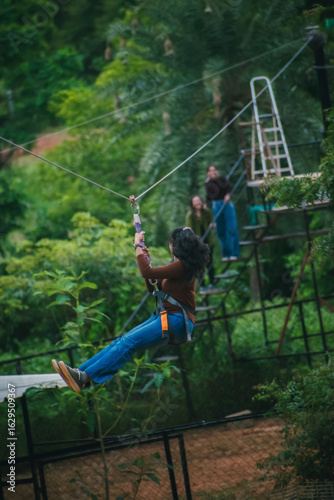 Young woman zip-lining through lush greenery in an Indian advent
