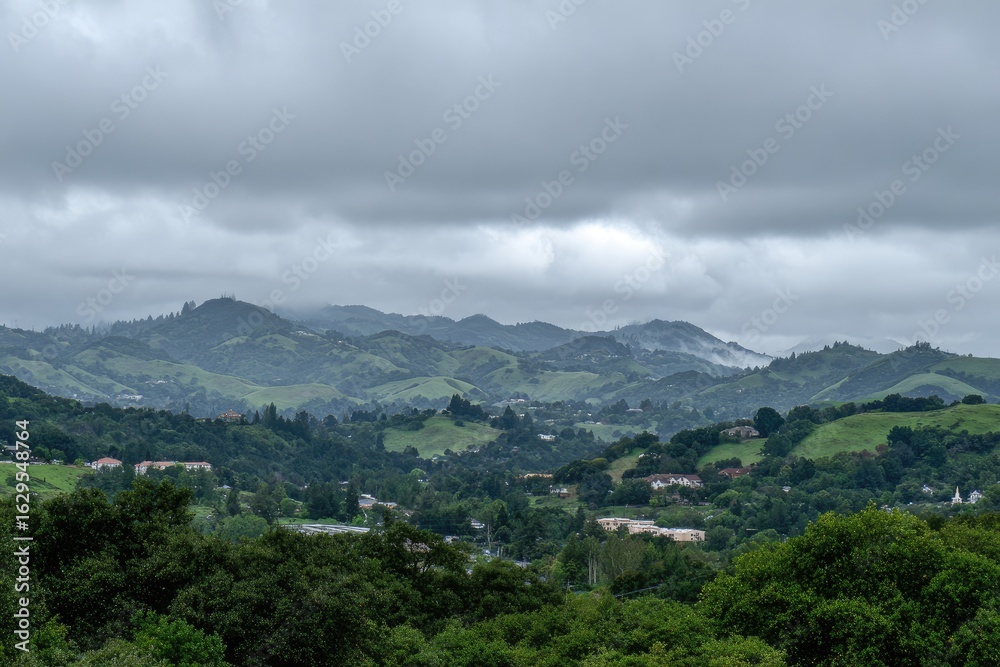 Naklejka premium Rolling hills blanketed by overcast sky