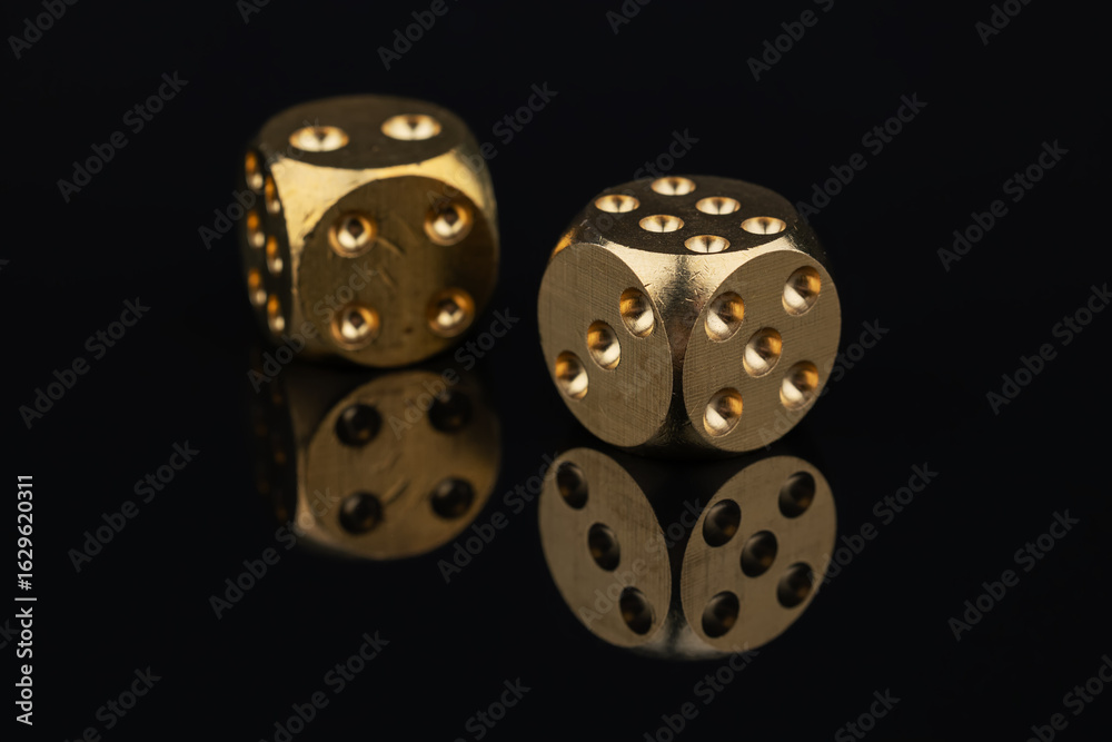 Two golden dice on black background Two golden dice on black background
