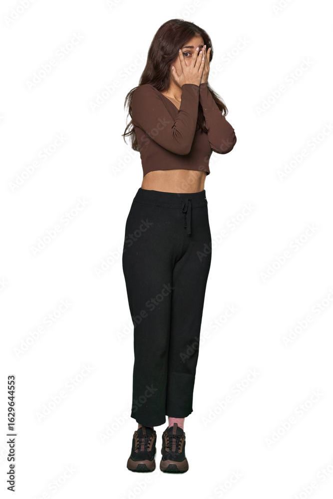 Middle Eastern woman, full body studio blink through fingers frightened and nervous. Middle Eastern woman, full body studio blink through fingers frightened and nervous.