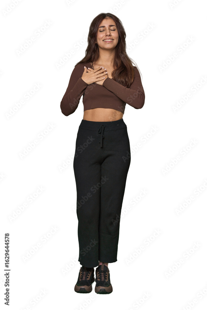 Middle Eastern woman, full body studio laughing keeping hands on heart, concept of happiness. Middle Eastern woman, full body studio laughing keeping hands on heart, concept of happiness.