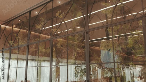 Wallpaper Mural Large arched glass wall reflects foliage and interior lights in elegant wedding venue setting Torontodigital.ca