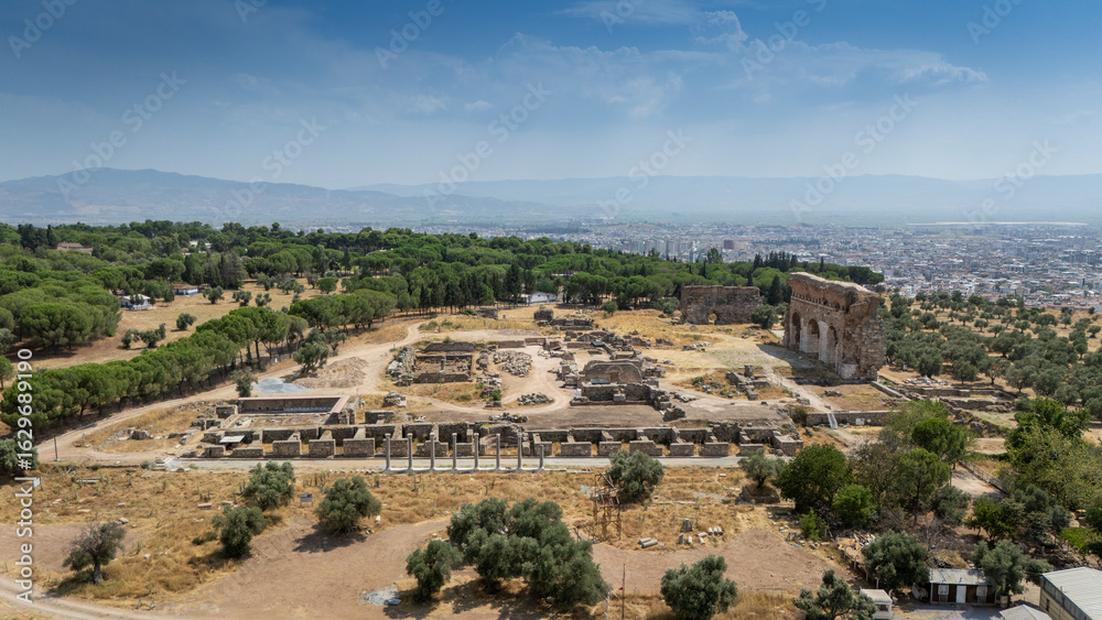 Obraz premium Ancient Ruins of Tralleis in Aydin, Turkey with Mountains and Olive Trees