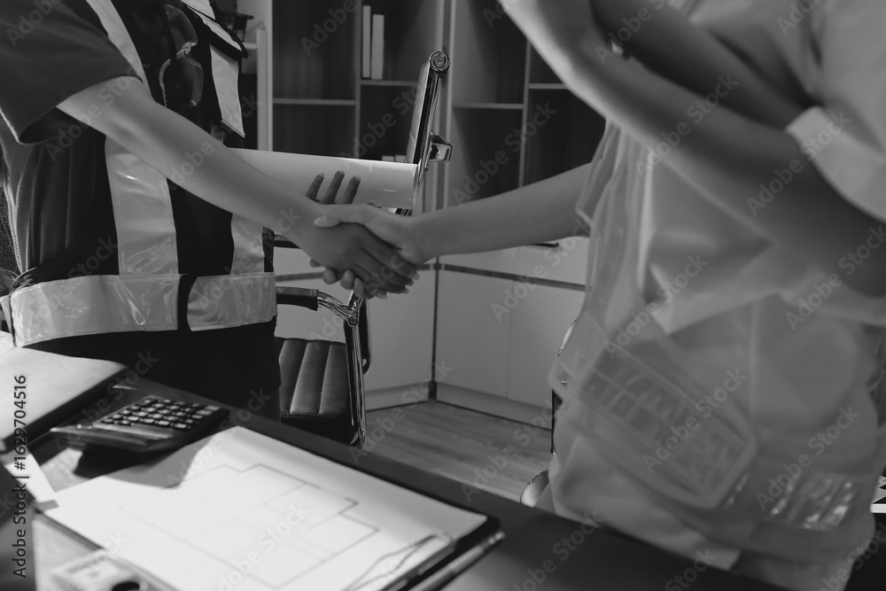 Obraz premium Closeup of team of industrial engineers meeting analyze machinery blueprints consult project on table in manufacturing factory. Working in manufacturing plant or production plant.