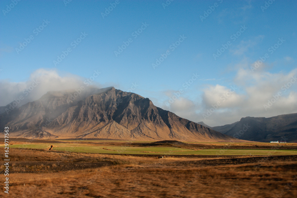 Fototapeta premium Snowy peaks reflect in a serene mountain lake at sunrise, a breathtaking natural Nordic landscape in Iceland
