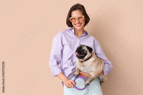 Young woman with cute pug d...