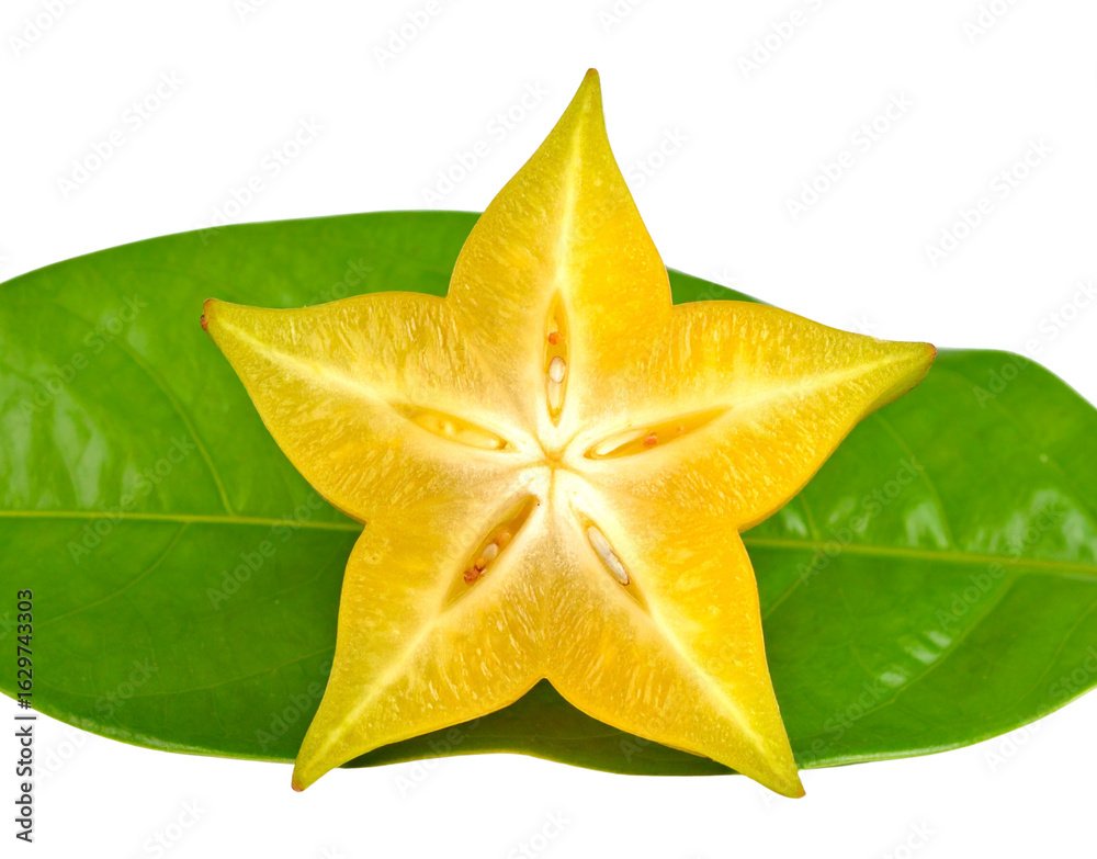 Fototapeta premium Vibrant yellow star fruit slice a crosssection of carambola with seeds resting on a green leaf.