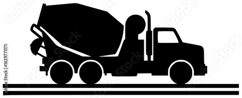 Cement mixer at construction site with cement blocks and truck driving down highway nearby