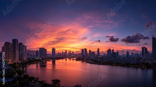 Wallpaper Mural A riverside city at sunset. The cool, orange-purple light beautifully reflects off the water. Tall buildings line the river, creating a romantic and peaceful atmosphere. Torontodigital.ca