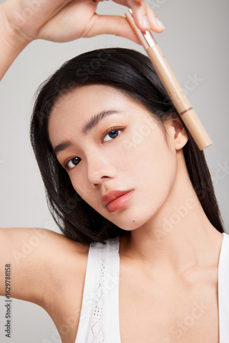 Asian female model showcasing beauty product.