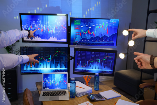 Hands of traders pointing a...