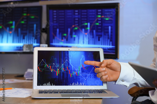 Male trader working with la...