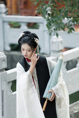Young woman in traditional attire with umbrella.