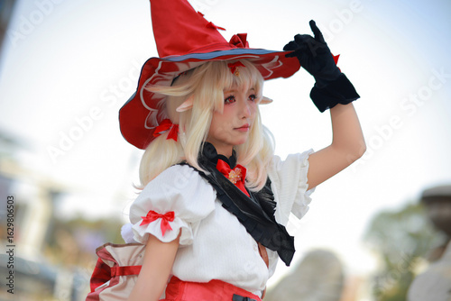 Young woman in cosplay with whimsical hat and outfit.