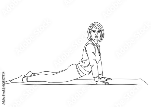 Woman doing a yoga pose on a mat, demonstrating the cobra stretch with her body.