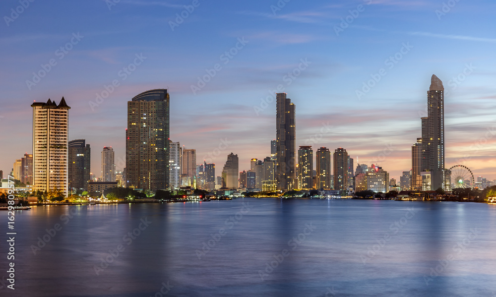 Obraz premium The Bangkok skyline at dawn, captured from Rama III Bridge. The city awakens under soft morning light, with skyscrapers silhouetted against a pastel sky