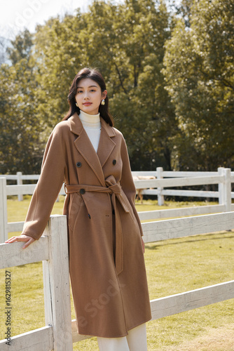 Elegant young woman in a brown coat outdoors.