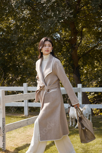 Elegant young woman walking in a serene outdoor setting.