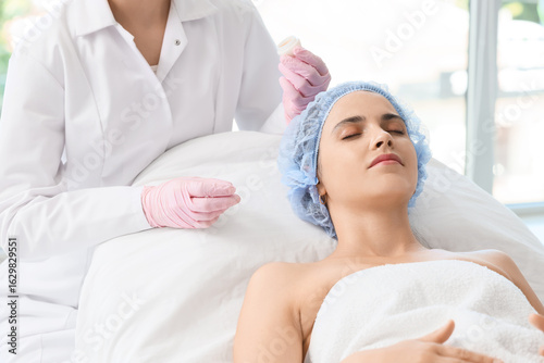 Beautician with jar of crea...