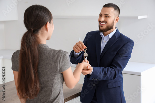 Male real estate agent givi...