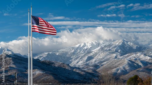 American flag waving over snowy mountains