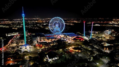 Night Illuminated Ferris Wheel In Orlando Florida United States. Breathtaking Aerial View Of Famous Ferris Wheel Of The City. Building Illuminated Urban. Town Up Above. City Landmark. Orlando Florida.