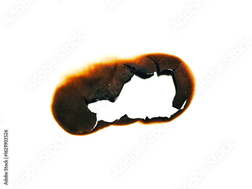 Close up of fire burned hole on white paper background. Burnt paper. A piece of scorched and torn paper with a fire burned hole and black scorch marks with stain.