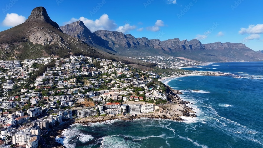 Fototapeta premium Camps Bay Beach In Cape Town Western Cape South Africa. Aerial View Of Stunning Beach With Crystal Clear Waters. Industrial Skyline Skyscrapers Amazing. Industrial Cityscape. Cape Town Western Cape.