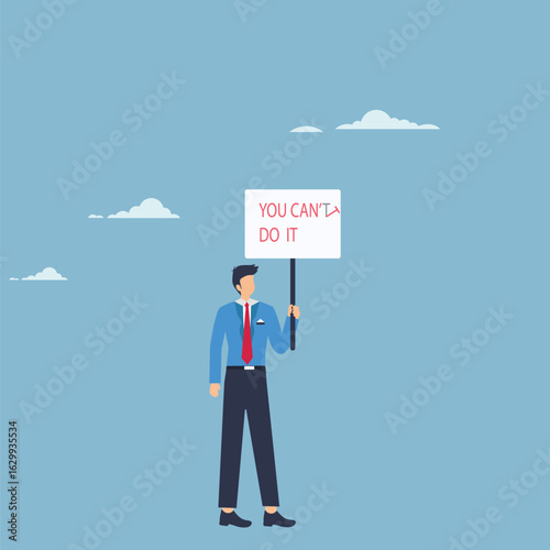 A businessman holding a sign with the message you cant do it, symbolizing the challenges and obstacles in achieving goals, but also the importance of motivation, determination, and a positive mindset