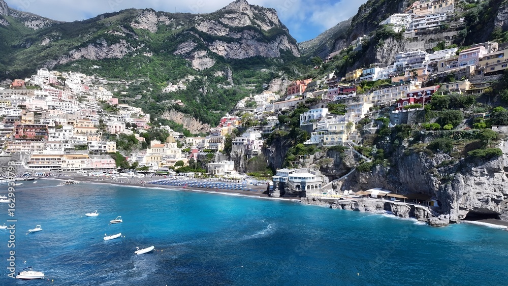 Naklejka premium Amalfi Coast In Positano Salerno Italy. Breathtaking Aerial View Of A Lush Tropical Coastline Scenery. Shore Clouds Sky Beach Sea. Seaside Panorama. Positano Salerno.