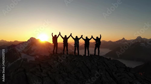 Hiking Team Celebrating on Mountain Peak at Sunset Achievement Concept