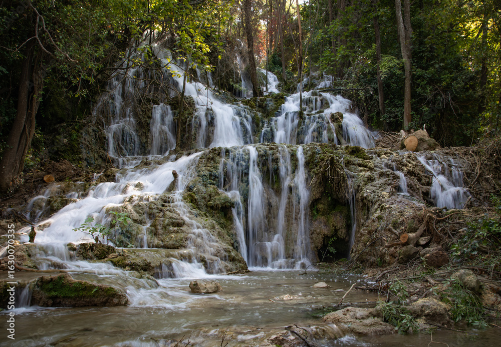 Obraz premium Peaceful waterfall in a Croatian national park surrounded by lush greenery and clear water. A stunning natural landscape ideal for travel, nature, adventure, and outdoor-themed content.