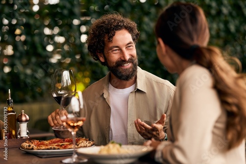 Fotografie Happy Couple Dining at Outdoor Restaurant with Food and Wine